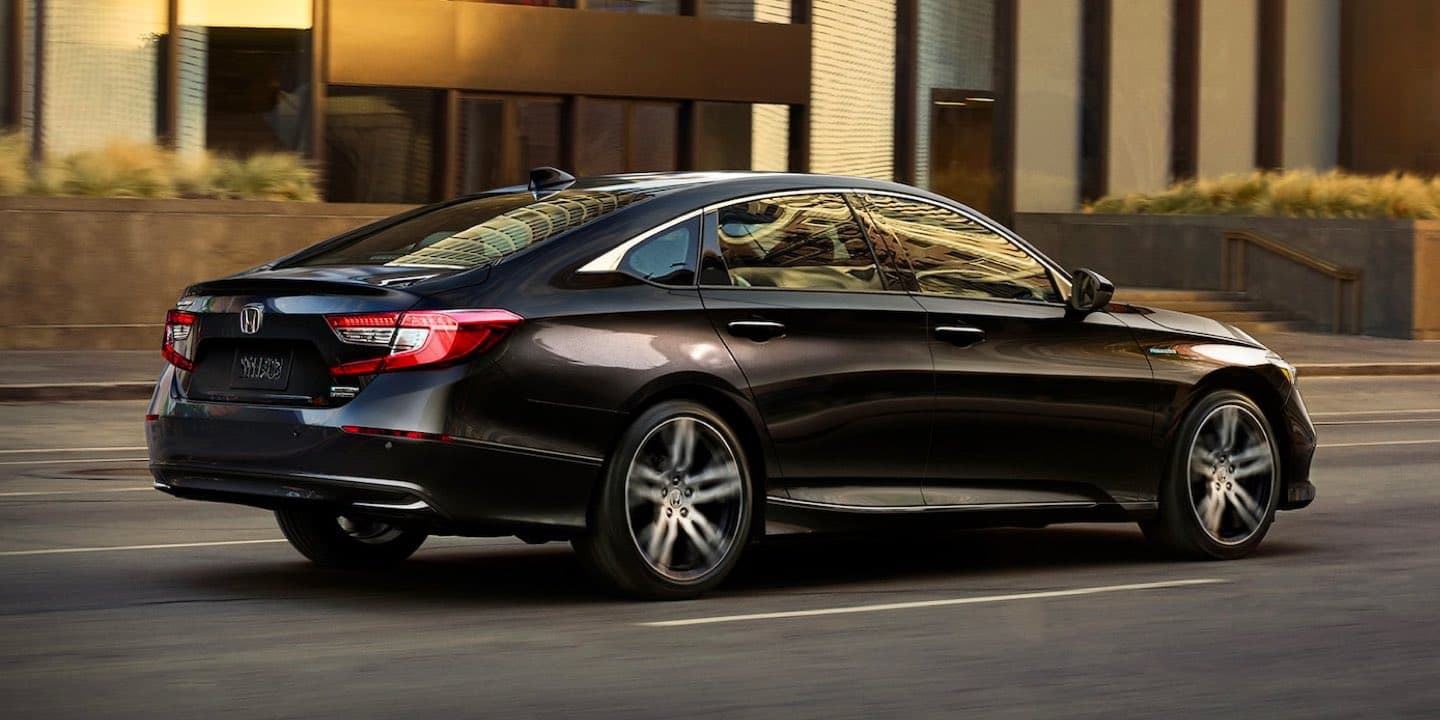 Black 2021 Honda Accord Hybrid driving on a city street